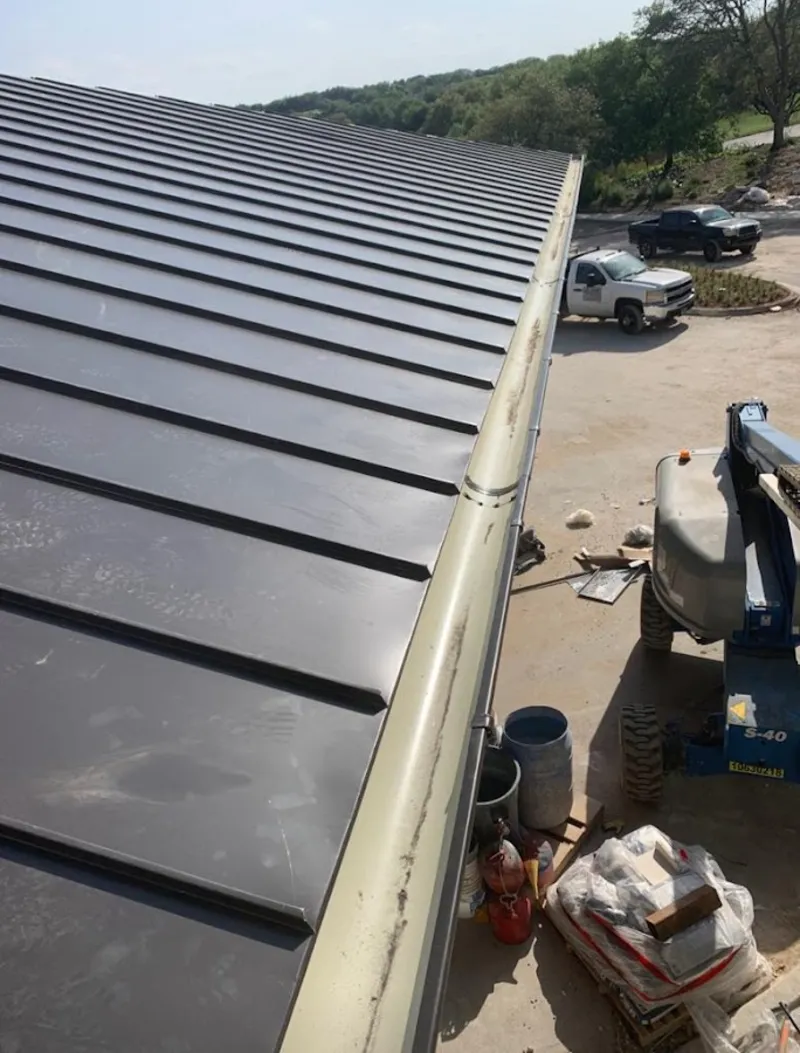Standing seam panel and gutter detail on a metal roofing jobsite in Suwanee
